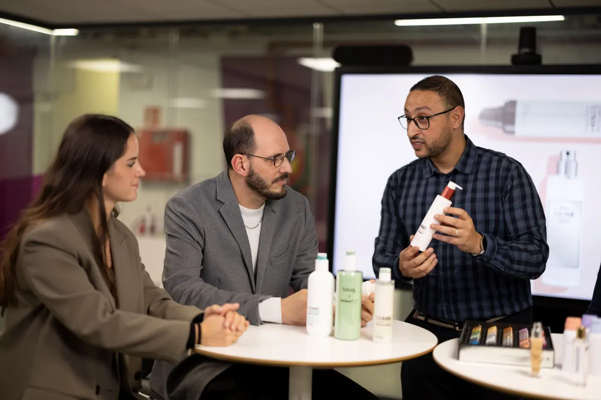 Three Aptar Employees sitting around a table looking at Aptar's lotion pumps